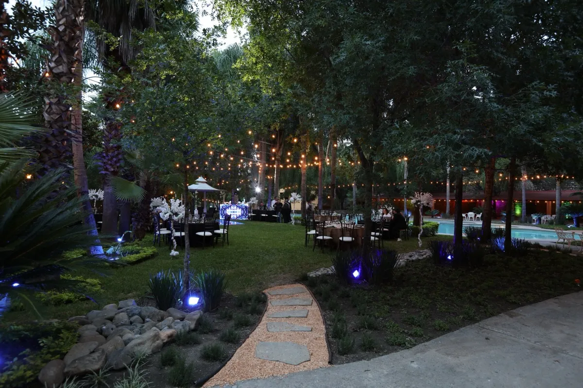 Jardín nocturno con sendero iluminado