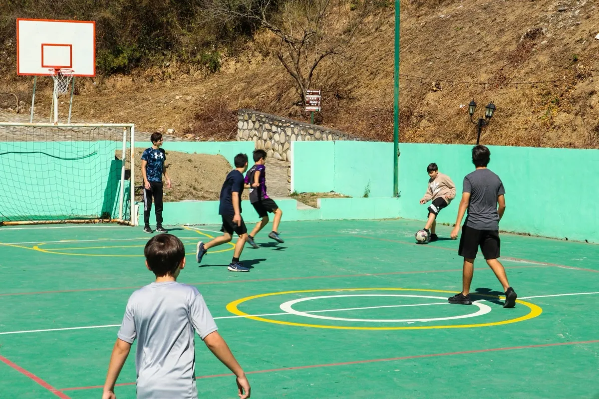 Niños jugando fútbol en multicancha